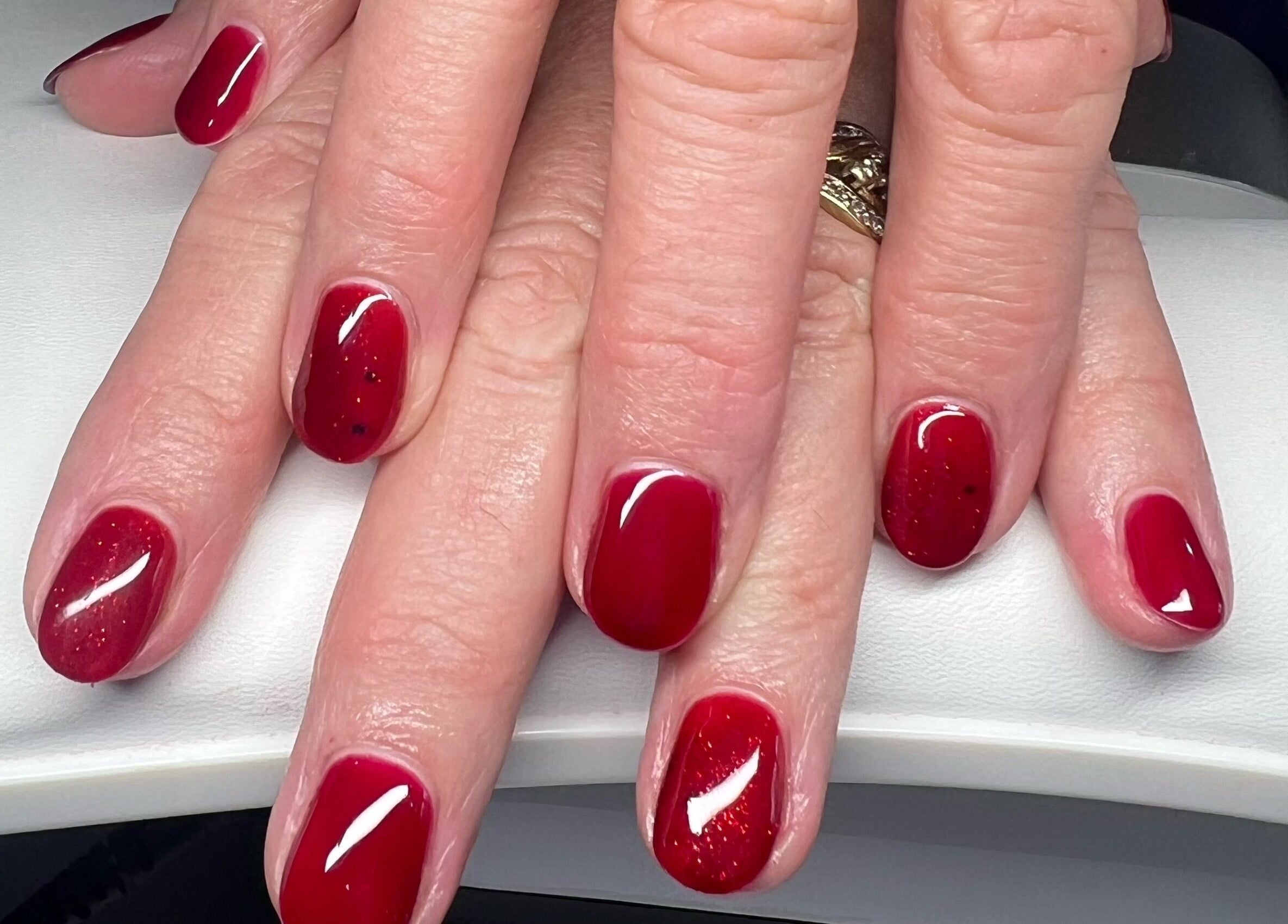Elegant red manicure at YG Beauty, Middlesbrough, GB, showcasing flawless glossy finish.