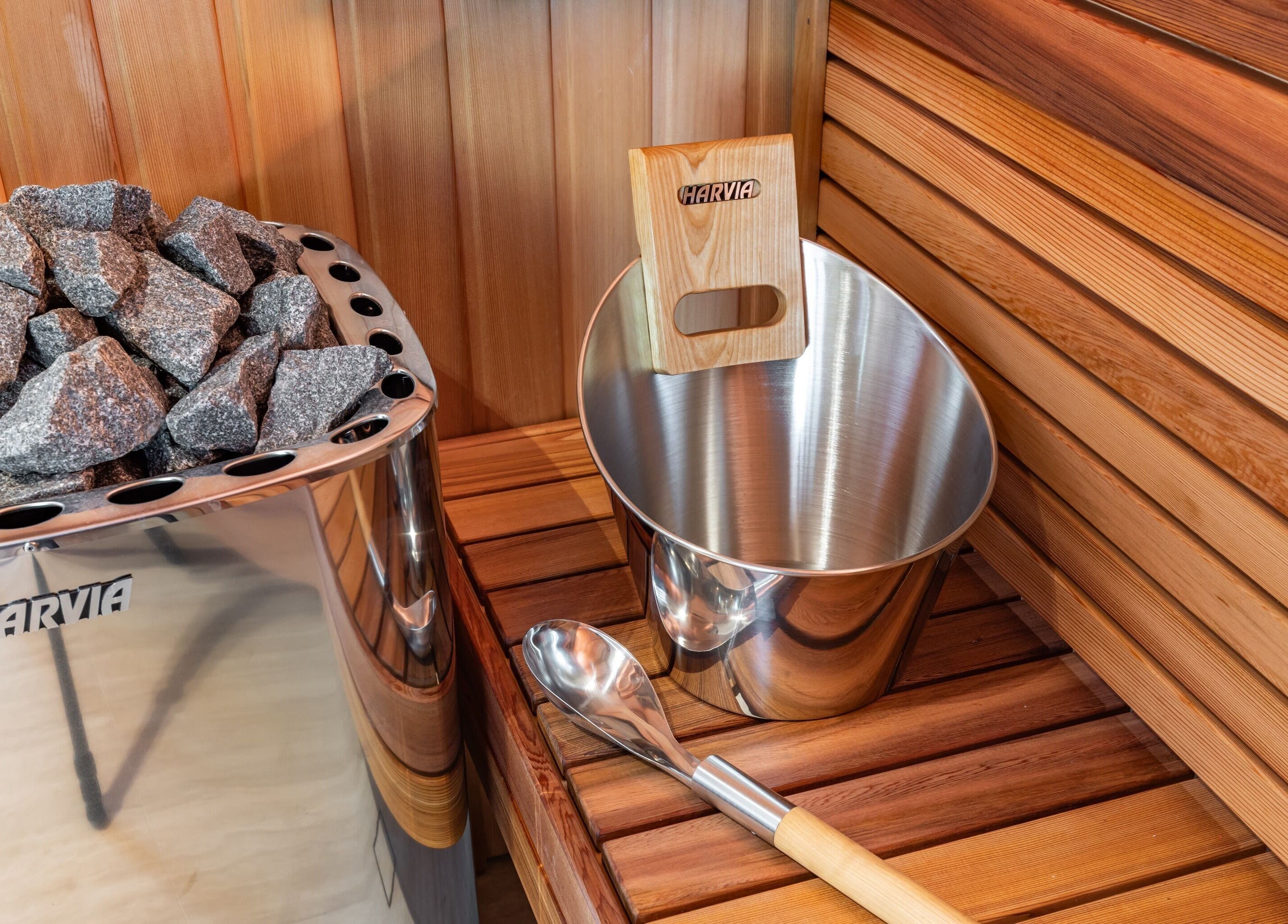 Sauna interior at Elite Body Recovery and Wellbeing, Maroubra, New South Wales, AU, featuring stones and bucket.