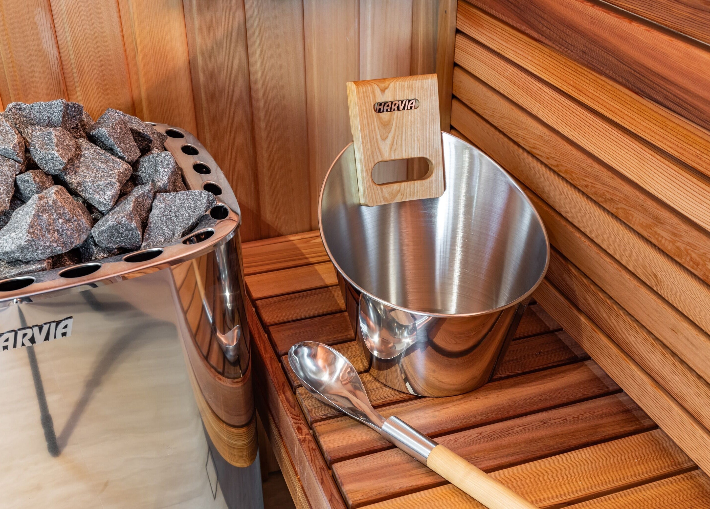Sauna interior at Elite Body Recovery and Wellbeing, Maroubra, New South Wales, AU, featuring stones and bucket.