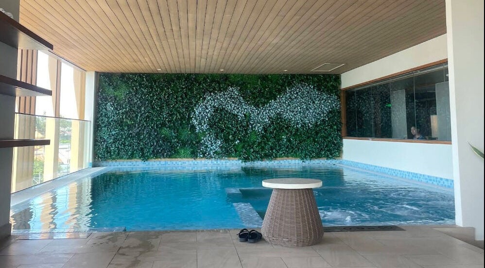 Tranquil pool area at Maia Spa by Fusion, Vũng Tàu, Bà Rịa - Vũng Tàu, VN, with a lush green wall.