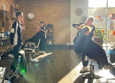 Professional barbers at Craig’s Barbershop, Thornton, New South Wales, AU, giving haircuts in bright sunlight.
