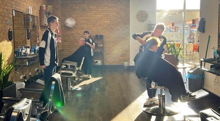 Professional barbers at Craig’s Barbershop, Thornton, New South Wales, AU, giving haircuts in bright sunlight.