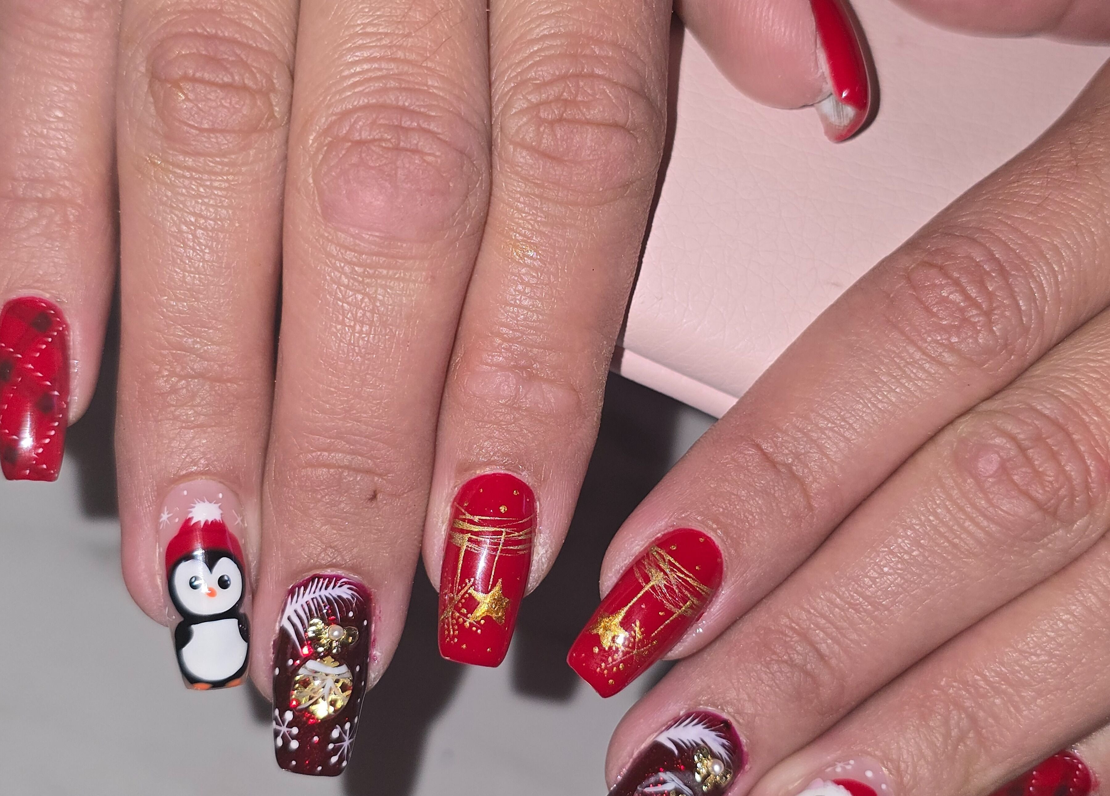 Art des ongles festif chez Lala Bellezza, Corte, Corse, FR, avec des motifs rouges et un pingouin.