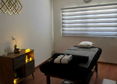 Sala de masaje en A Hache Salón y Spa, Monclova, Coahuila De Zaragoza, MX, con iluminación suave y cama terapéutica.