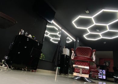 Interior moderno de Barbarian Barber Studio en Valle Del Cauca, CO, con sillas de barbería y luz hexagonal.