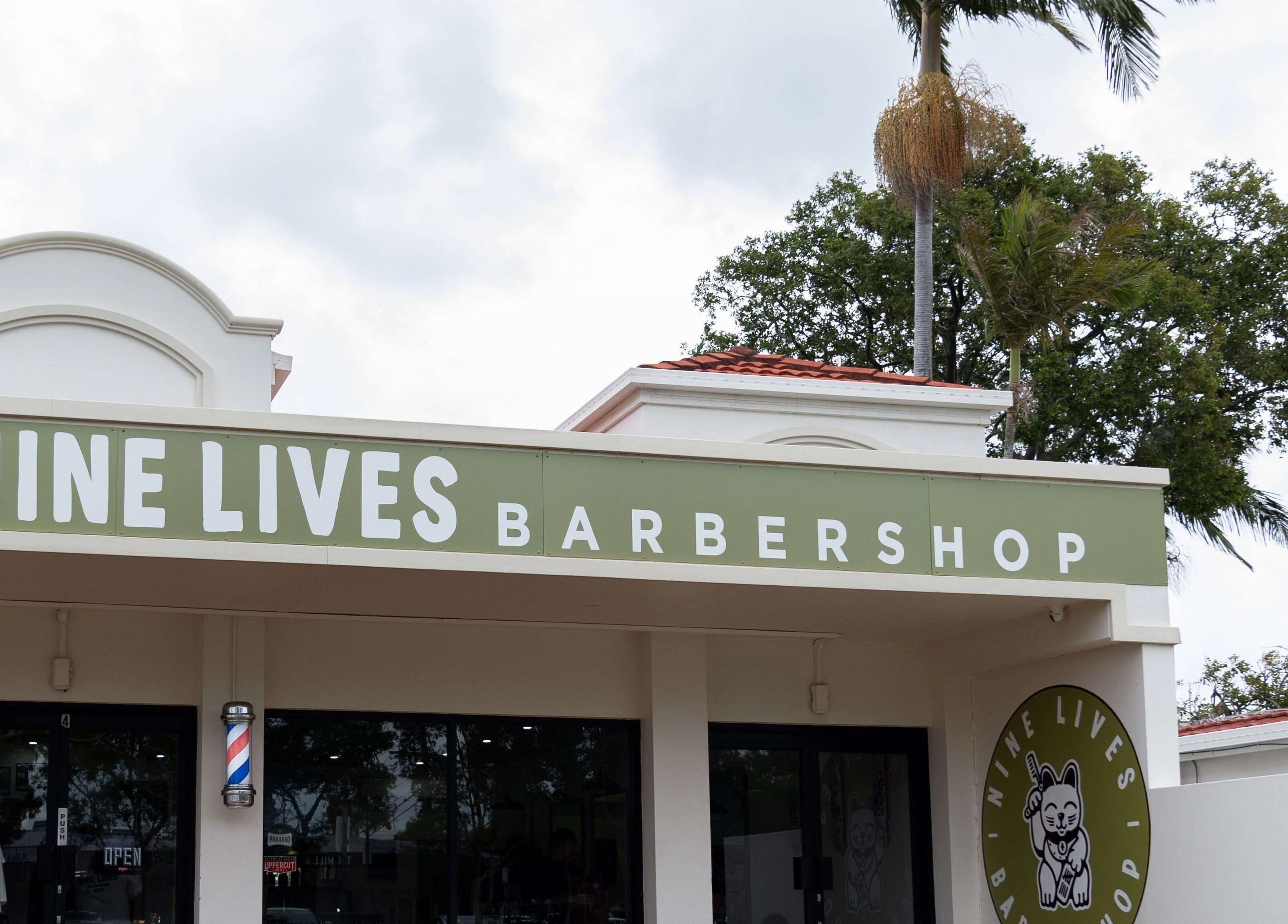 Exterior of Nine Lives Barbershop, Paradise Point, Queensland, AU, showing a welcoming entrance.