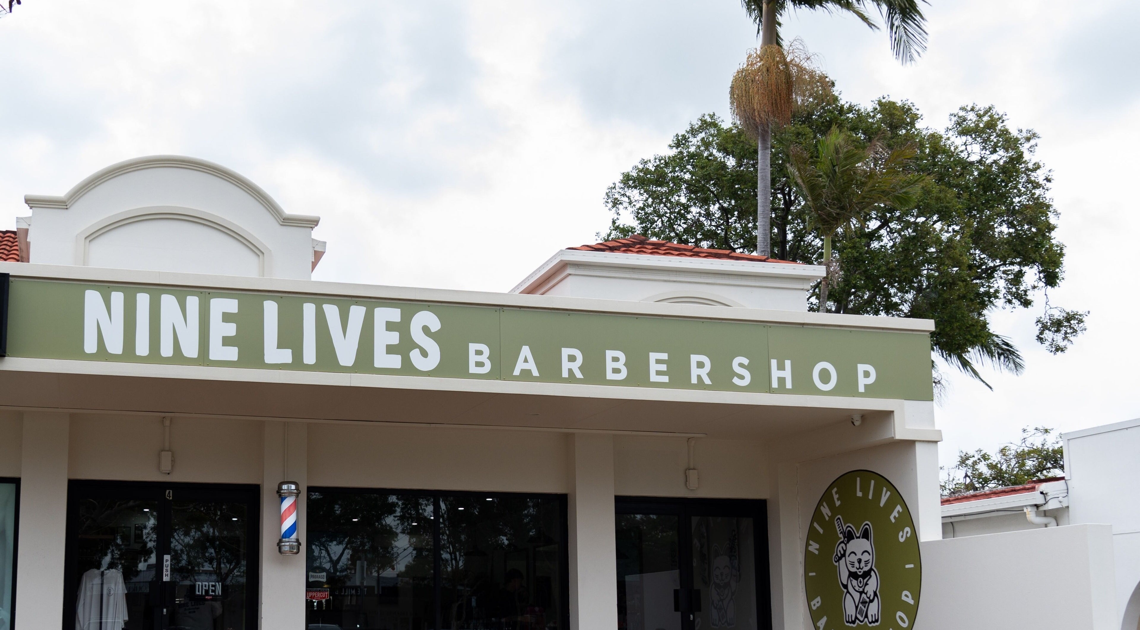 Exterior of Nine Lives Barbershop, Paradise Point, Queensland, AU, showing a welcoming entrance.