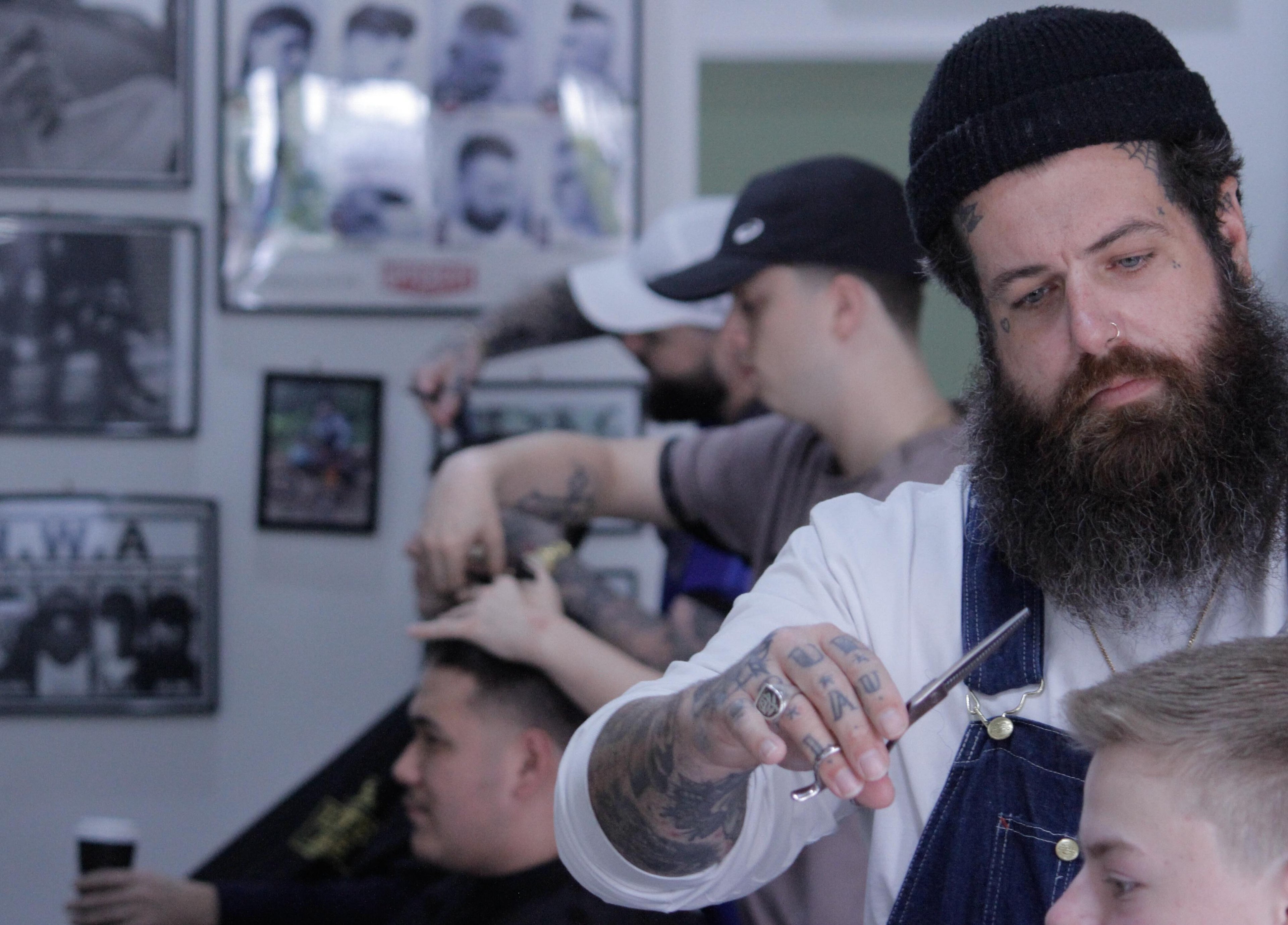 Skilled barber styling hair at Nine Lives Barbershop in Paradise Point, Queensland, AU.