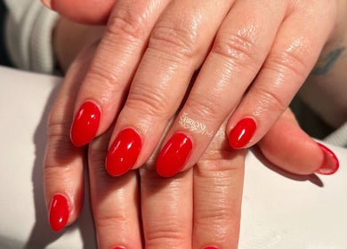 Elegant manicure featuring bold red nails at Brioni Nails, Prince Albert, Saskatchewan, CA.
