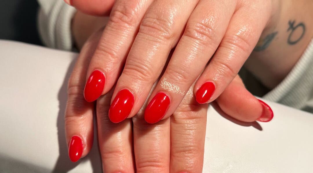 Elegant manicure featuring bold red nails at Brioni Nails, Prince Albert, Saskatchewan, CA.