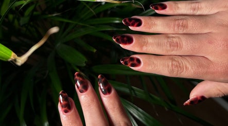 Elegant marble nails at Details On Me, Athina, GR, showcasing stylish hand care amidst lush greenery.