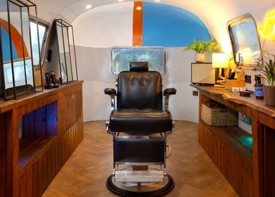 Cozy salon space at Winding Creative in Canterbury, England, GB featuring vintage barber chair and wooden counters.