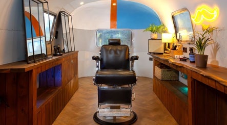 Cozy salon space at Winding Creative in Canterbury, England, GB featuring vintage barber chair and wooden counters.