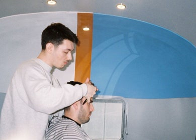 Stylist at Winding Creative in Canterbury, England, GB giving a modern haircut in a sleek salon.