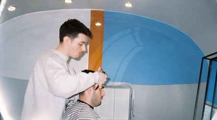Stylist at Winding Creative in Canterbury, England, GB giving a modern haircut in a sleek salon.
