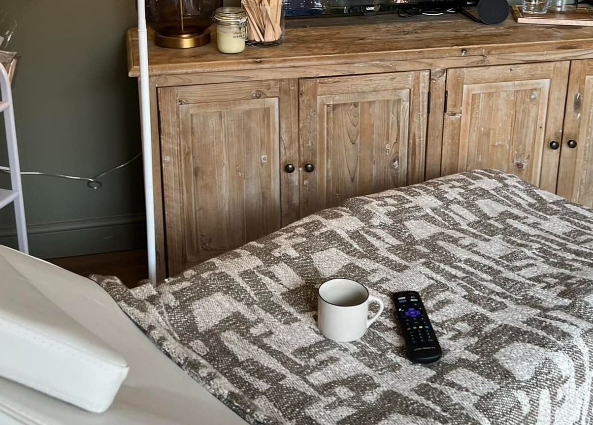 Relaxing treatment room at The Wax Hut, Kinsham Tewkesbury, with a comfy bed and warm wooden decor.