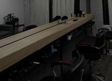 Interior moderno de KLSBARBERIA en Córdoba, Córdoba, AR con asientos estilizados y decoración minimalista.