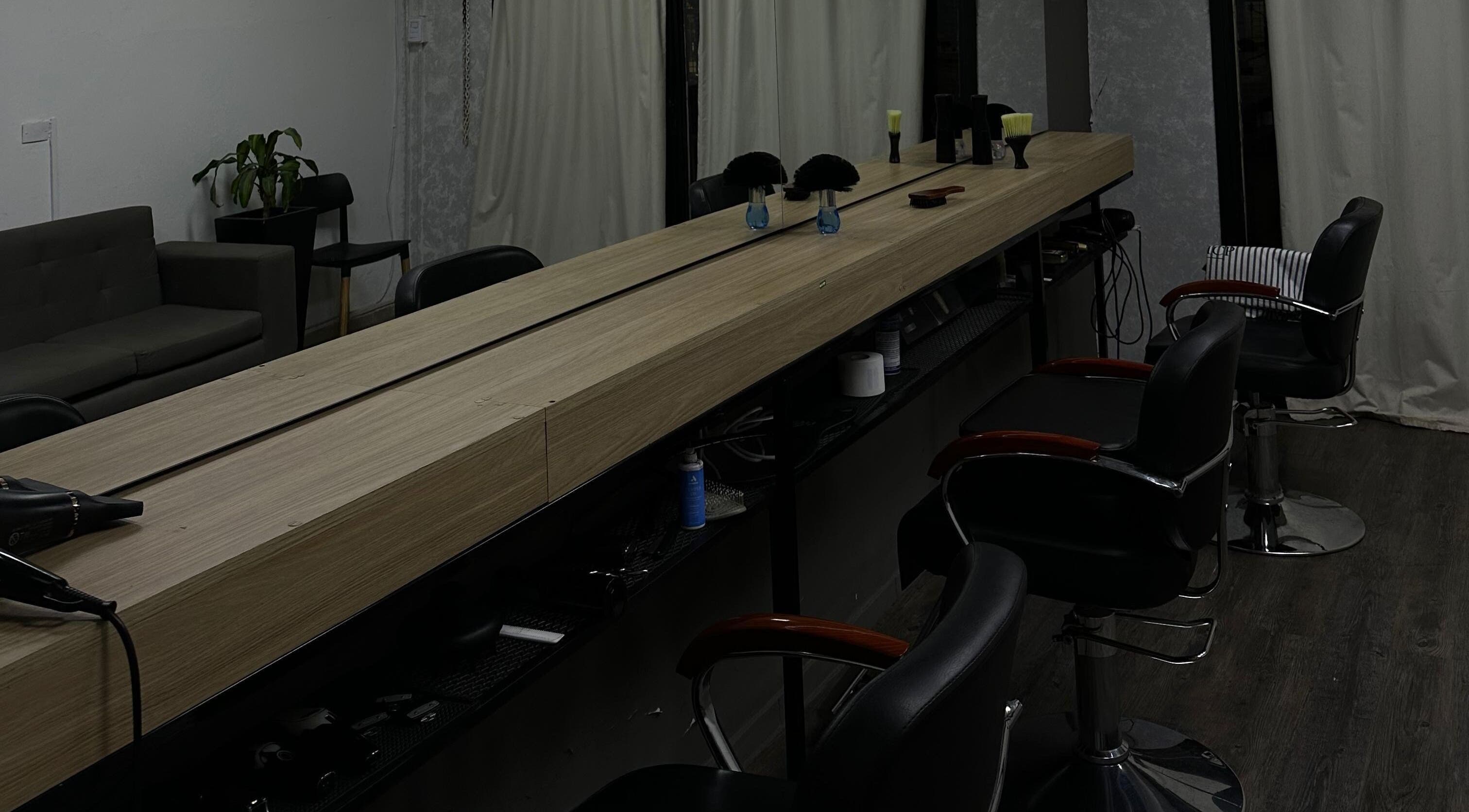 Interior moderno de KLSBARBERIA en Córdoba, Córdoba, AR con asientos estilizados y decoración minimalista.