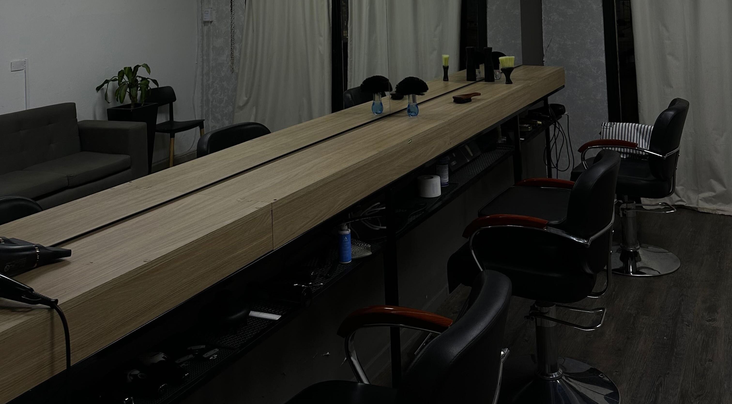 Interior moderno de KLSBARBERIA en Córdoba, Córdoba, AR con asientos estilizados y decoración minimalista.