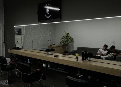 Interior de KLSBARBERIA en Córdoba, Córdoba, AR, mostrando modernos sillones y decoración minimalista.