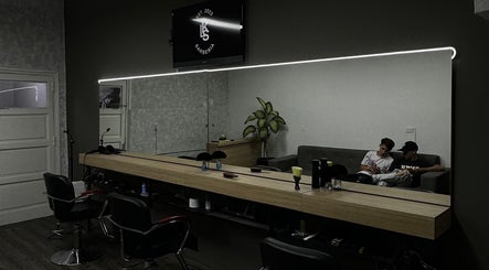 Interior de KLSBARBERIA en Córdoba, Córdoba, AR, mostrando modernos sillones y decoración minimalista.