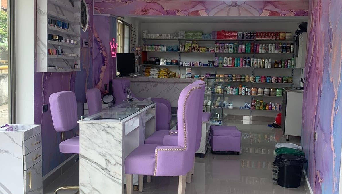 Interior de salón DIVINAS Y COSTOSAS en Medellín, Antioquia, CO. Sillas lilas y productos de belleza en estantes.