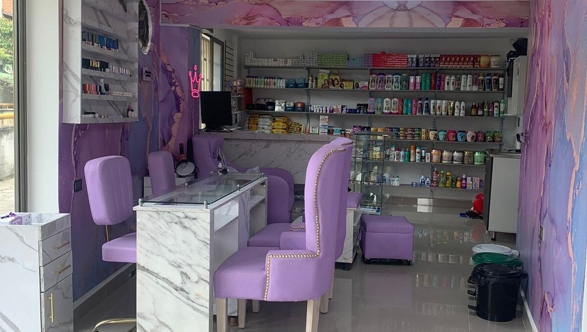 Interior de salón DIVINAS Y COSTOSAS en Medellín, Antioquia, CO. Sillas lilas y productos de belleza en estantes.
