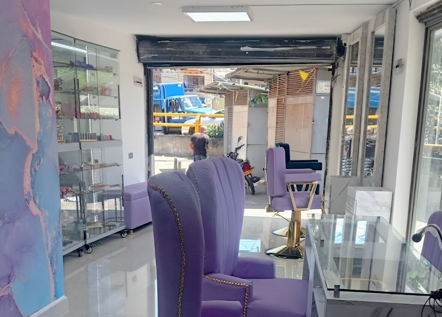 Interior moderno y elegante de DIVINAS Y COSTOSAS en Medellín, Antioquia, CO con sillas lavanda.
