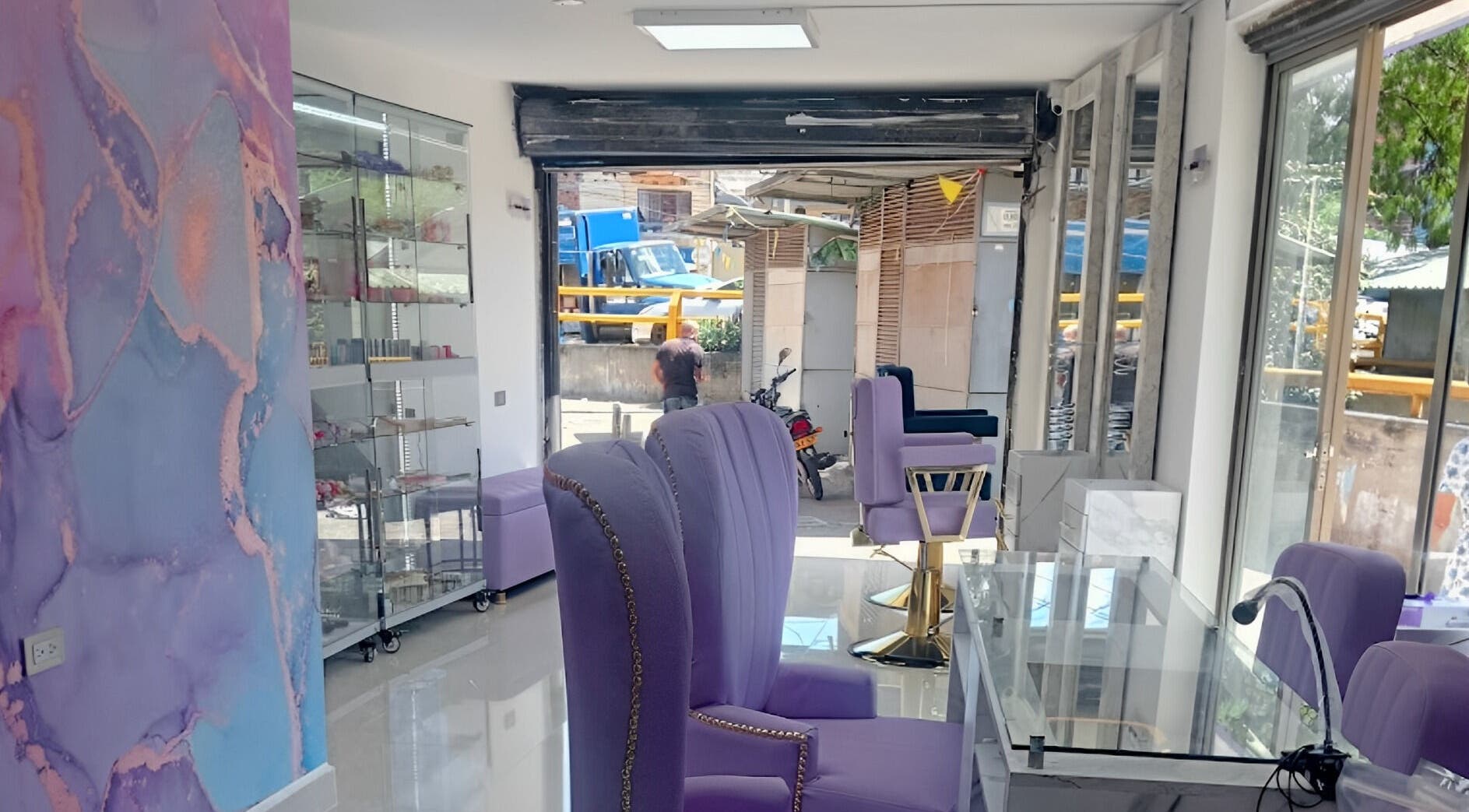 Interior moderno y elegante de DIVINAS Y COSTOSAS en Medellín, Antioquia, CO con sillas lavanda.