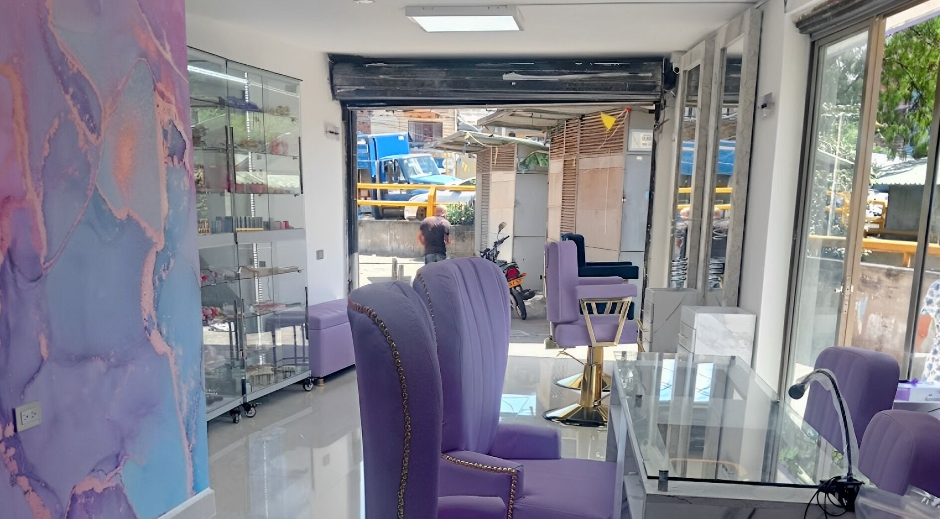 Interior moderno y elegante de DIVINAS Y COSTOSAS en Medellín, Antioquia, CO con sillas lavanda.