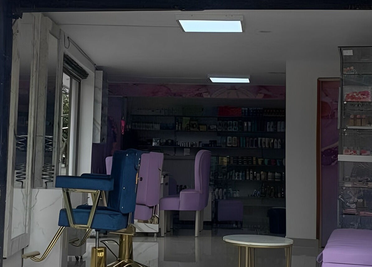 Interior moderno y elegante de DIVINAS Y COSTOSAS en Medellín, Antioquia, CO, con sillas violetas y decoración sofisticada.