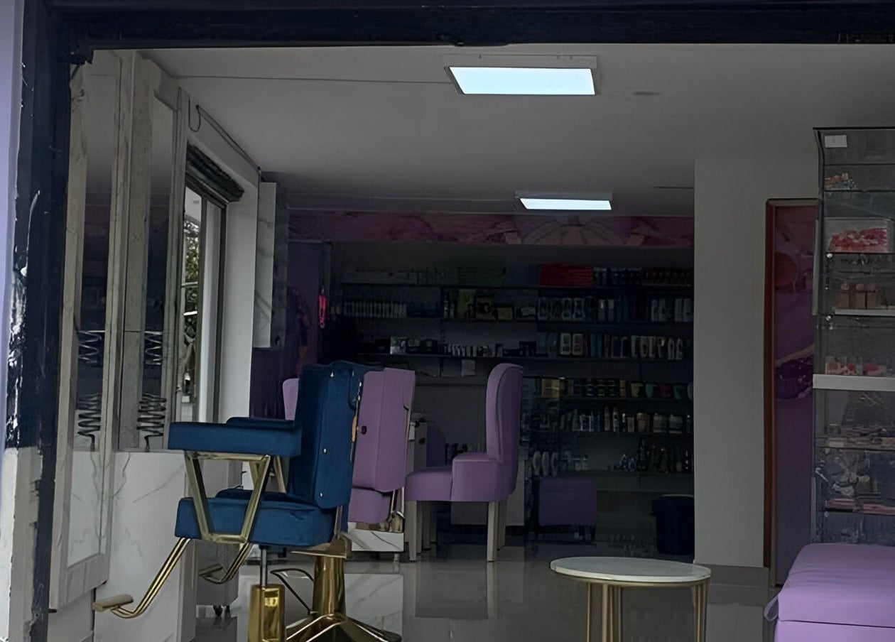 Interior elegante de DIVINAS Y COSTOSAS en Medellín, Antioquia, CO con sillas púrpuras y estanterías.