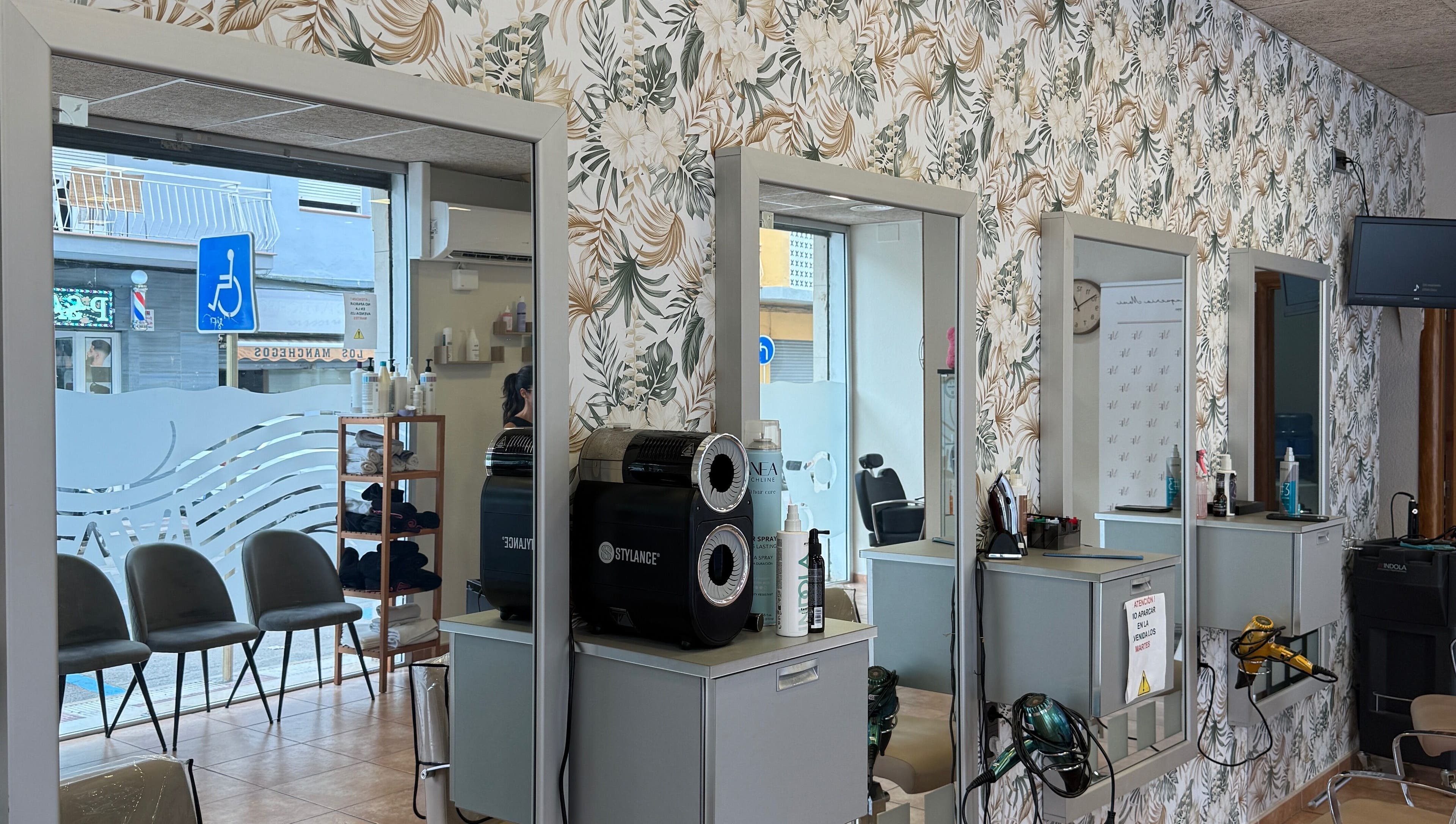 Interior elegante de Perruqueria Mavi en Blanes, Catalunya, ES con espejos y decoración moderna.