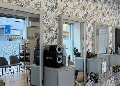 Interior elegante de Perruqueria Mavi en Blanes, Catalunya, ES con espejos y decoración moderna.
