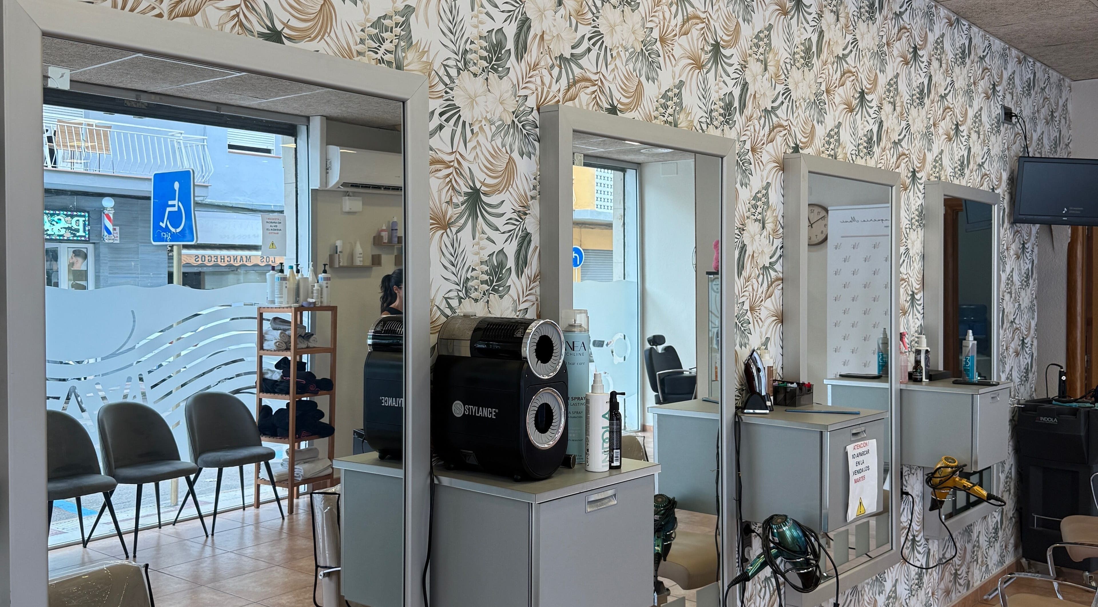 Interior elegante de Perruqueria Mavi en Blanes, Catalunya, ES con espejos y decoración moderna.