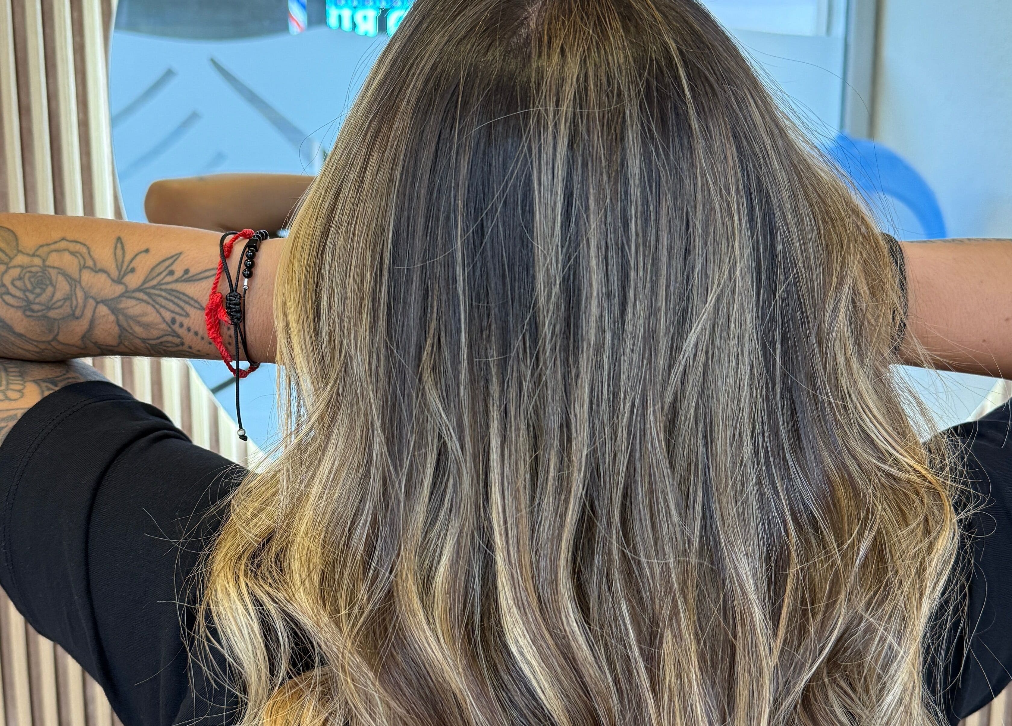 Estilo moderno de cabello en Perruqueria Mavi, Blanes, Catalunya, ES, destacando color y tatuajes artísticos.