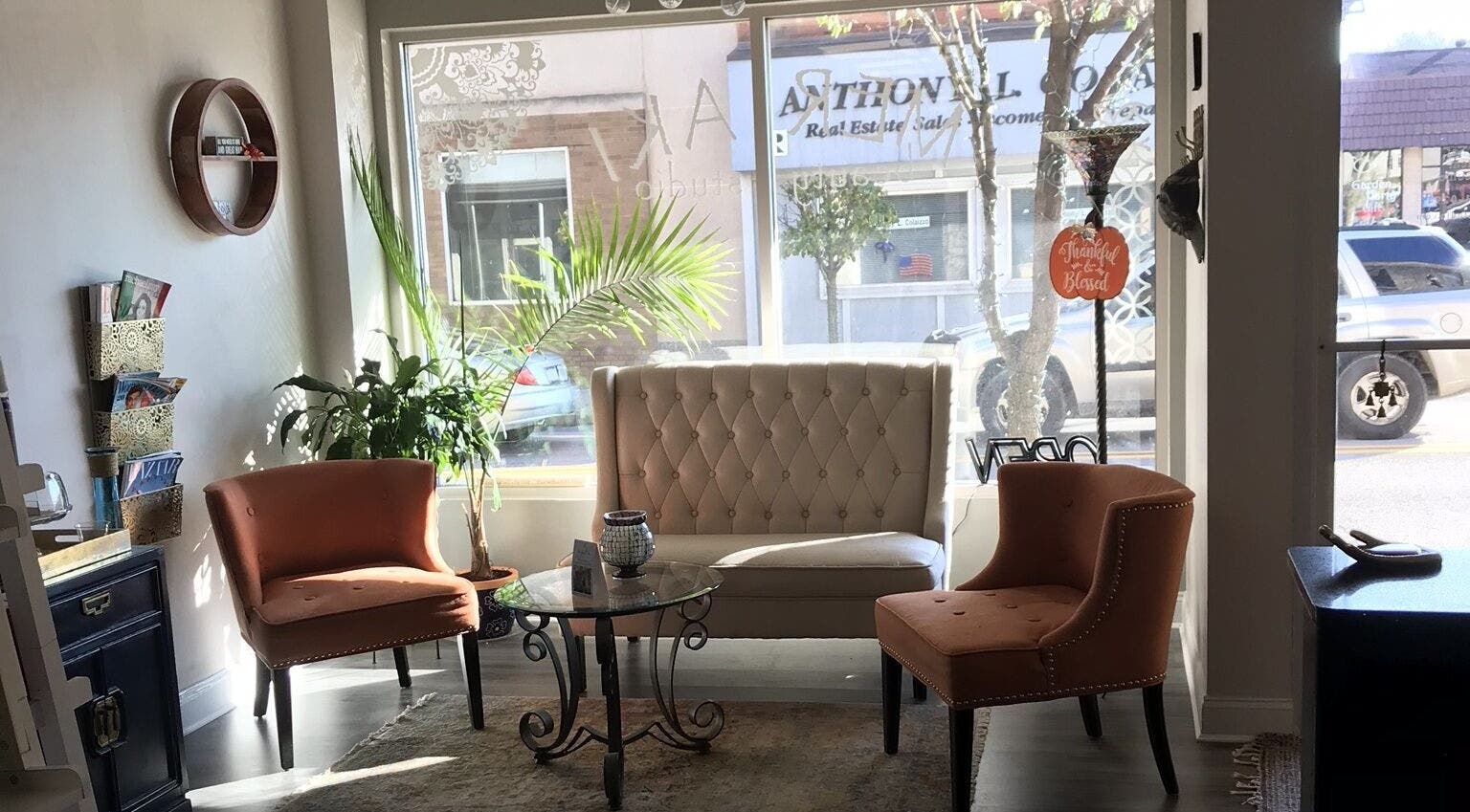 Elegant seating area at Meraki Beauty Studio in Canonsburg, Pennsylvania with natural light and cozy decor.
