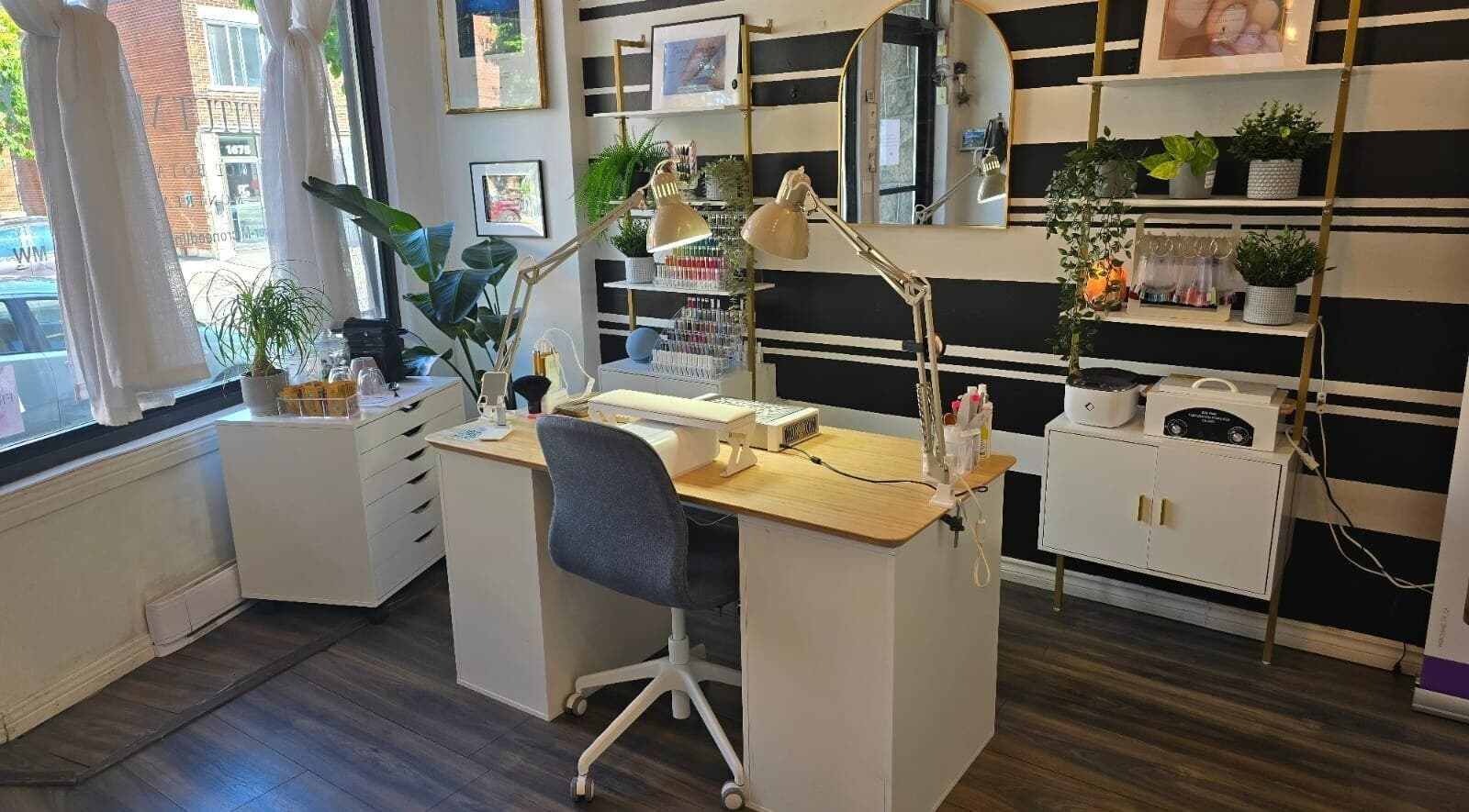 Intérieur lumineux de La Frenchie Onglerie à Montréal, Québec, CA, avec un bureau élégant et des plantes.