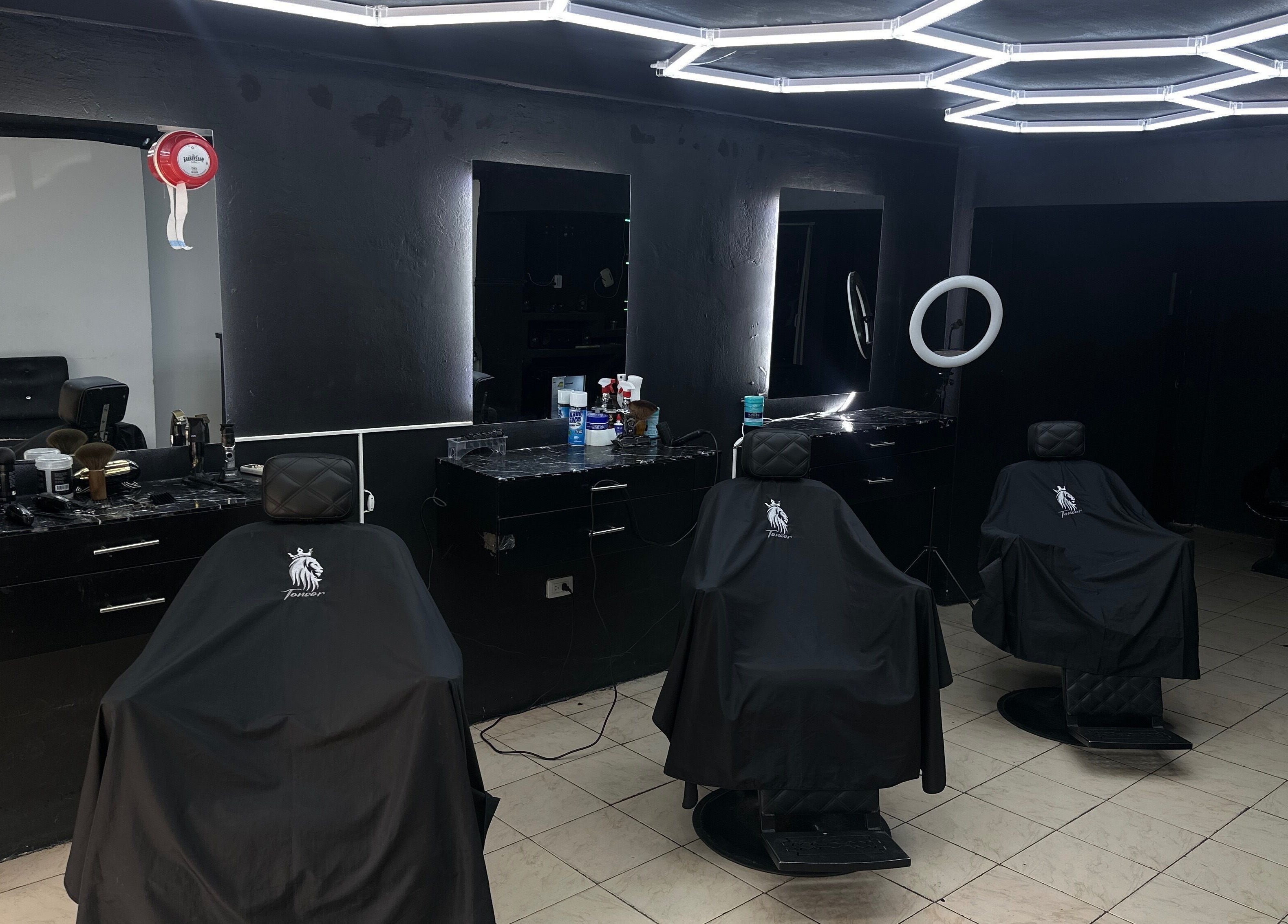 Interior moderno de Tonsor Studio en San Cristóbal, Táchira, VE con sillas y espejos iluminados.