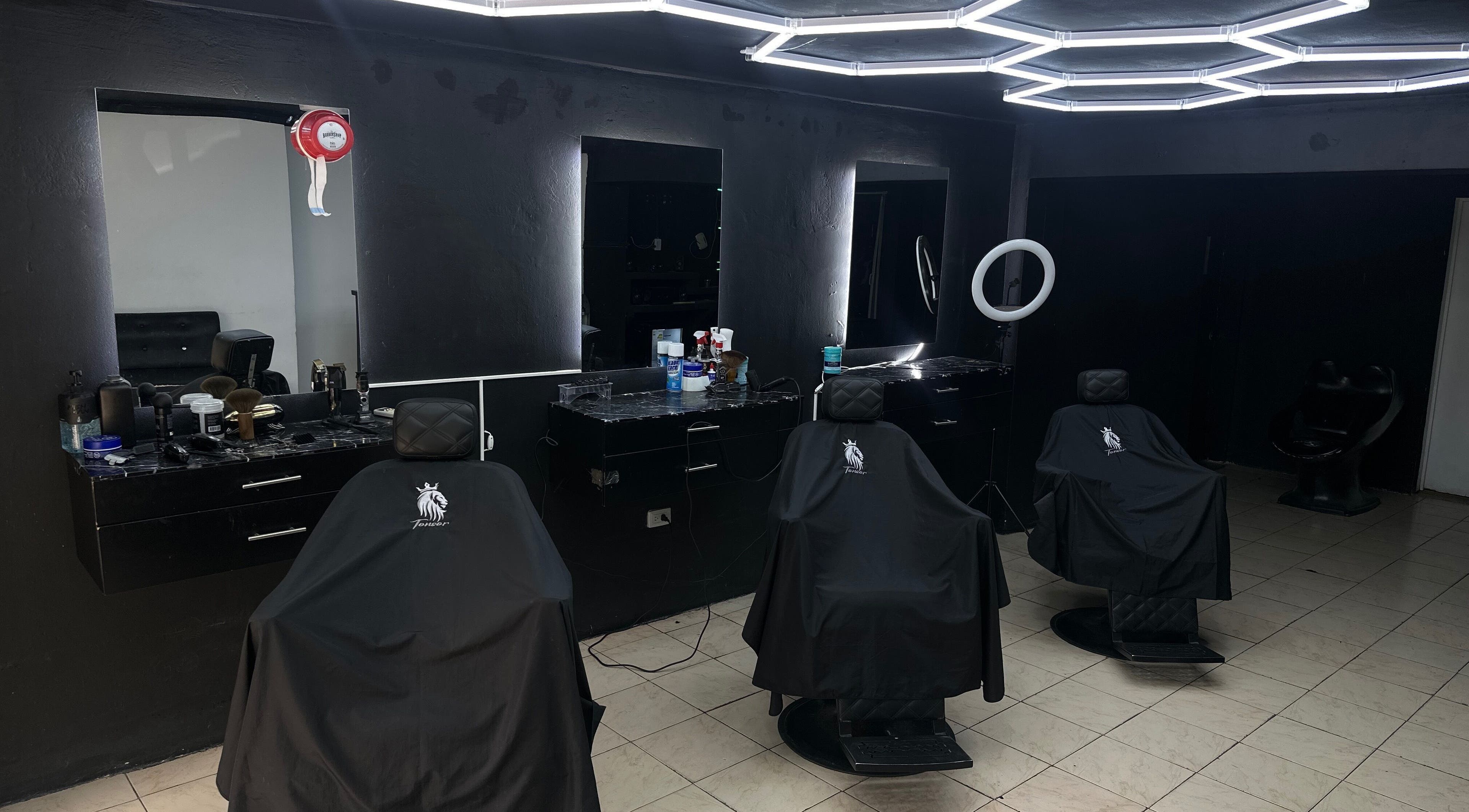 Interior moderno de Tonsor Studio en San Cristóbal, Táchira, VE con sillas y espejos iluminados.