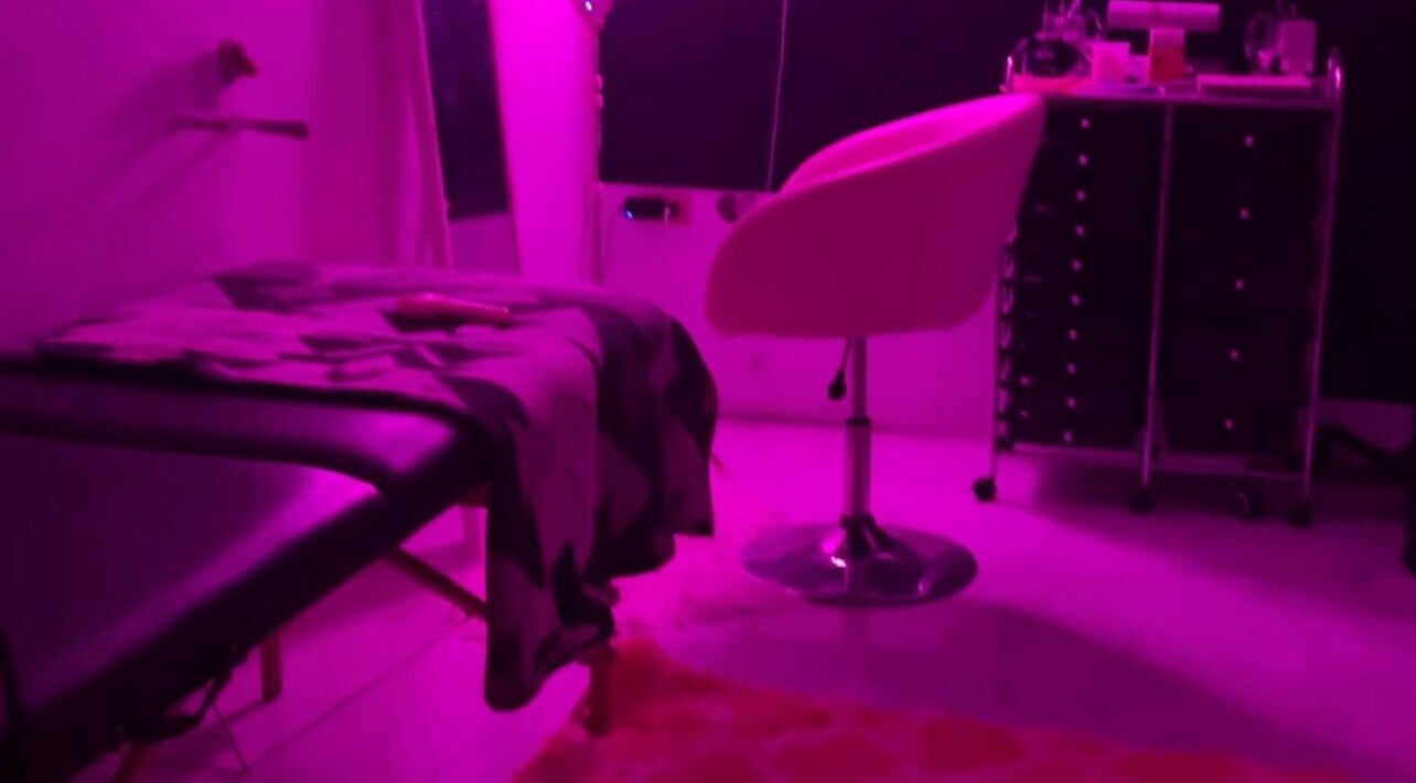 Relaxing pink-lit treatment room at Kkouture.ja in Kingston, St. Andrew Parish, JM, featuring a plush chair and table.