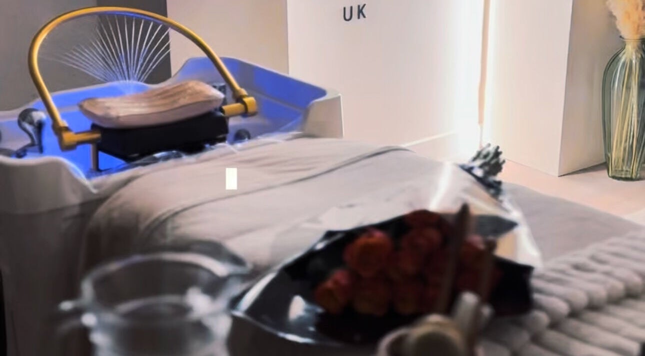 Relaxing spa bed at The Head Spa UK - London South, London, England, GB, illuminated in soft blue light.