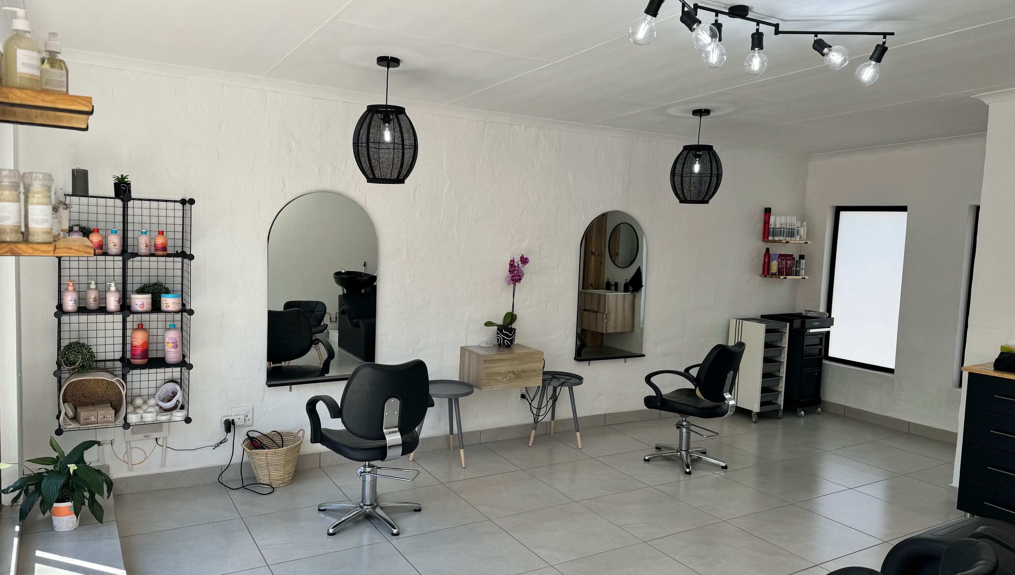 Modern salon interior at Lu Bella Hair, Modimolle, Limpopo, ZA with stylish chairs and product display.