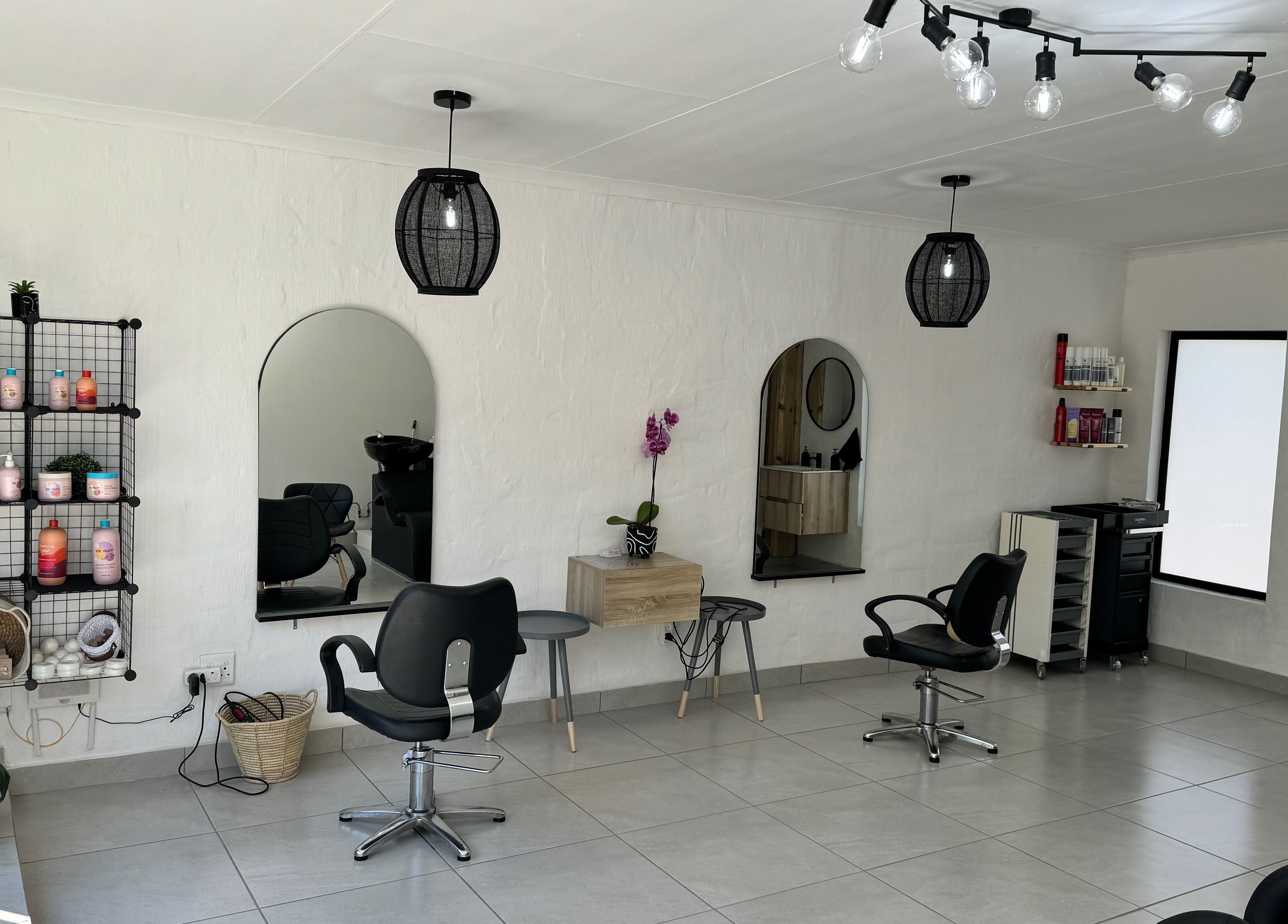 Modern salon interior at Lu Bella Hair, Modimolle, Limpopo, ZA with stylish chairs and product display.