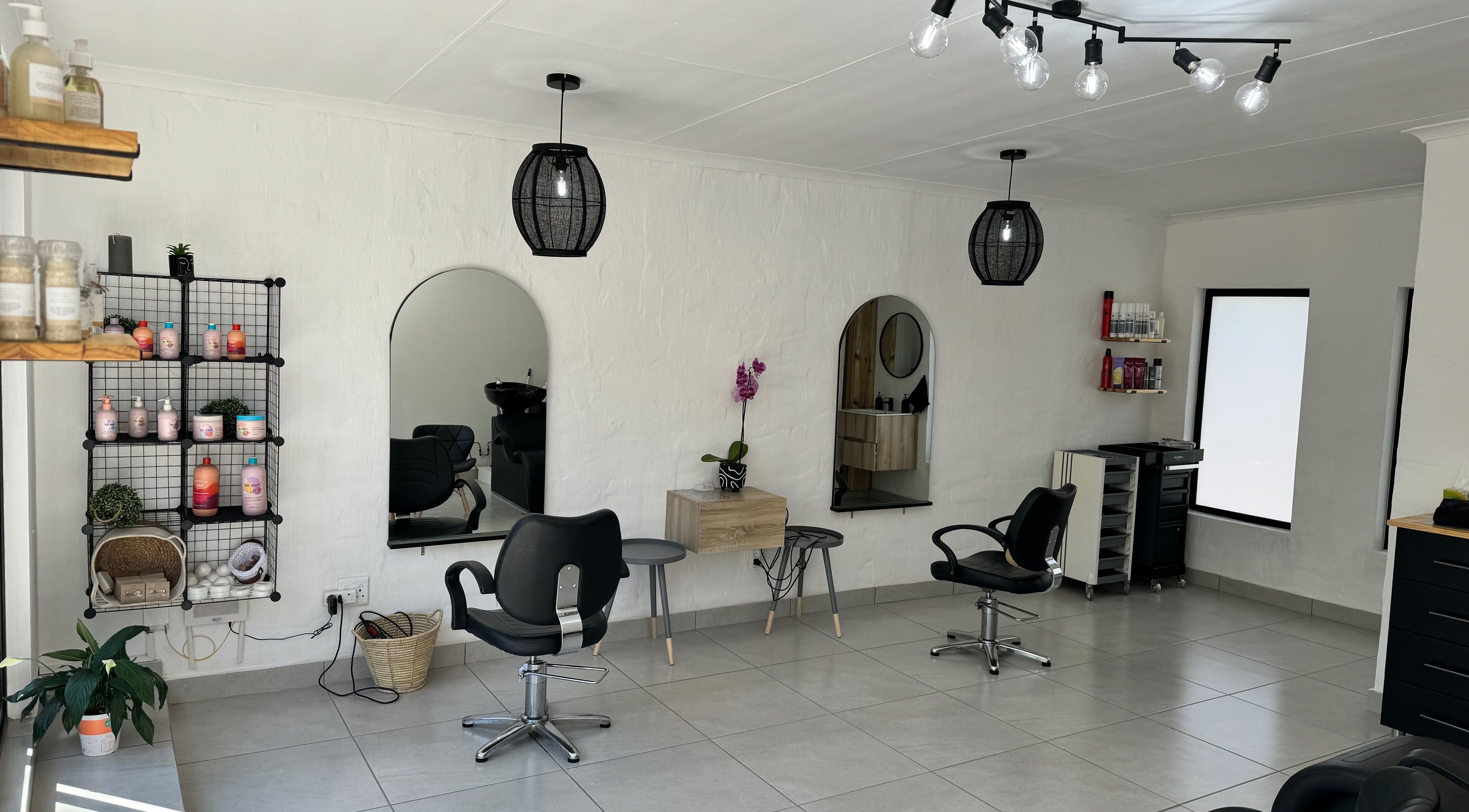 Modern salon interior at Lu Bella Hair, Modimolle, Limpopo, ZA with stylish chairs and product display.
