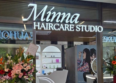 Entrance of Minna Haircare Studio at Plantation Crescent (Tengah), Singapore, with vibrant floral displays.