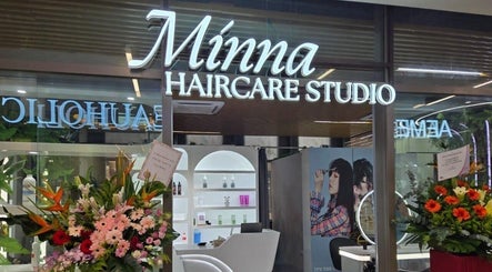 Entrance of Minna Haircare Studio at Plantation Crescent (Tengah), Singapore, with vibrant floral displays.