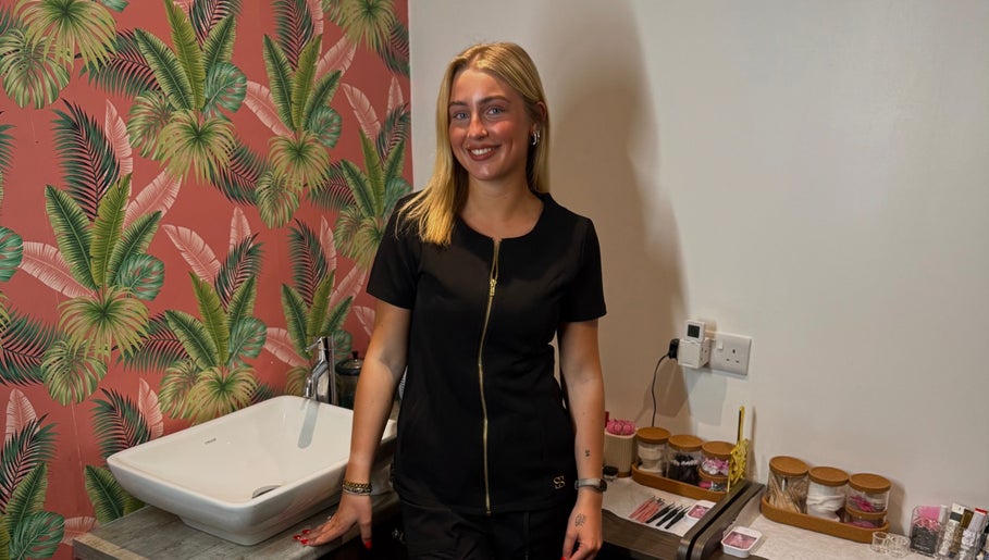 Beauty therapist at Bronzed Beauty, Bangor, Northern Ireland, GB standing by a tropical-themed wall.