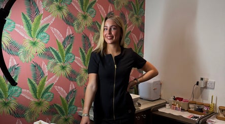 A stylish beautician at Bronzed Beauty, Bangor, Northern Ireland, GB, creating elegance amid tropical decor.