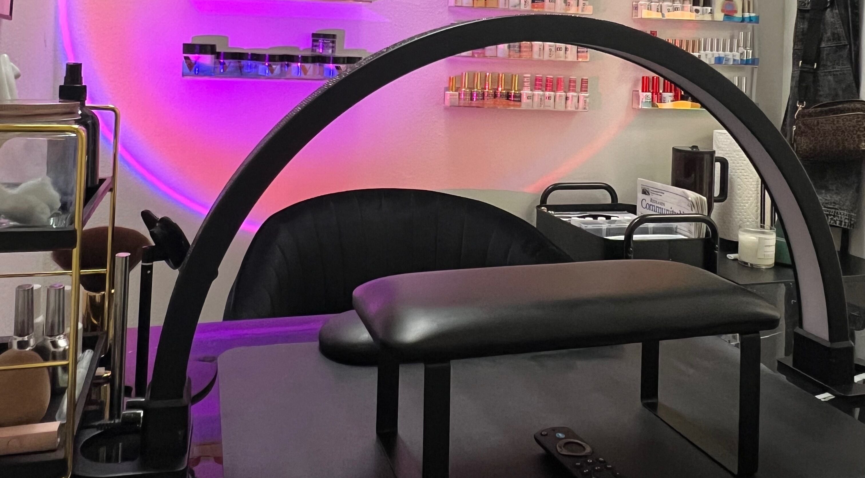 Modern manicure station at Clawed and Polished in Redlands, California, US with vibrant lighting and polish display.
